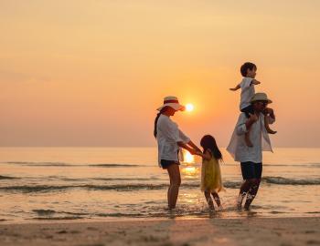 family on beach at sunset