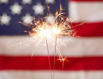 sparkler in front of an American Flag