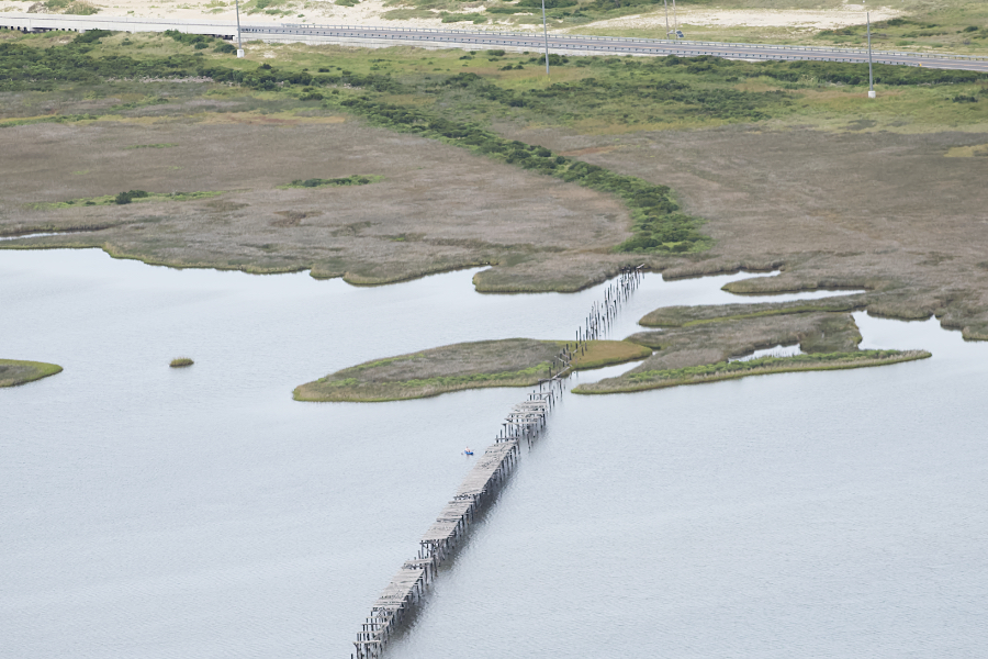 the remnants of the first bridge to span New Inlet can be clearly seen in this aerial view. the remnants of the first bridge to span New Inlet can be clearly seen in this aerial view.